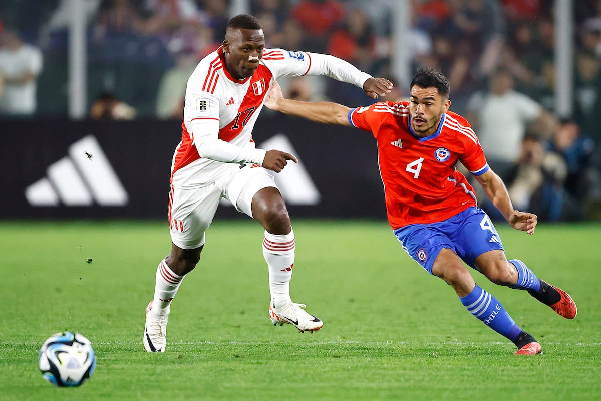 Luis Advíncula y Gabriel Suazo disputan un balón en Chile vs Perú