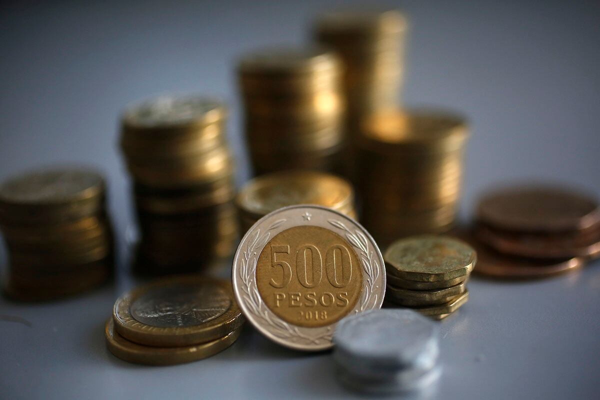 Monedas chilenas de diferentes montos apiladas en una mesa.