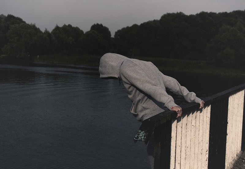 Imagen alusiva al suicidio: Un hombre a punto de lanzarse de un puente