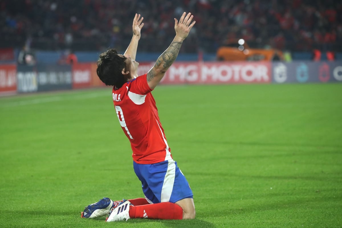 Víctor Dávila y una postal de su consagratoria noche en el Estadio Nacional tras anotar dos goles por La Roja ante Paraguay.