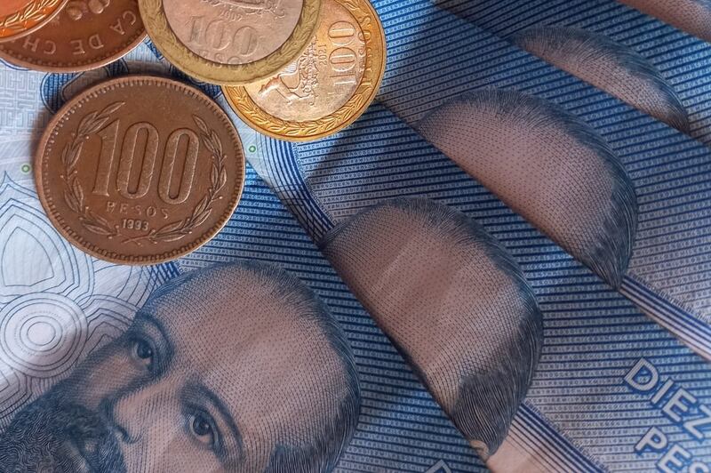 Billetes y monedas de distintos montos apilados.